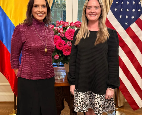 Invitadas en la Residencia Oficial de la Embajada de Colombia en Washington, entre las banderas de Colombia y Estados Unidos