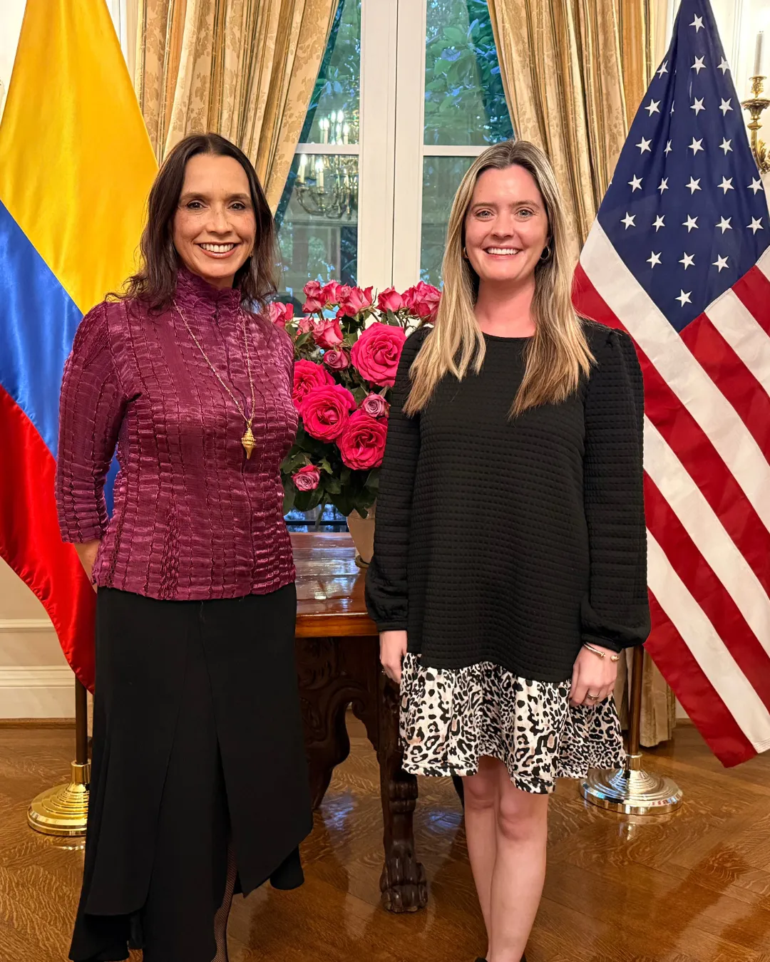 Invitadas en la Residencia Oficial de la Embajada de Colombia en Washington, entre las banderas de Colombia y Estados Unidos
